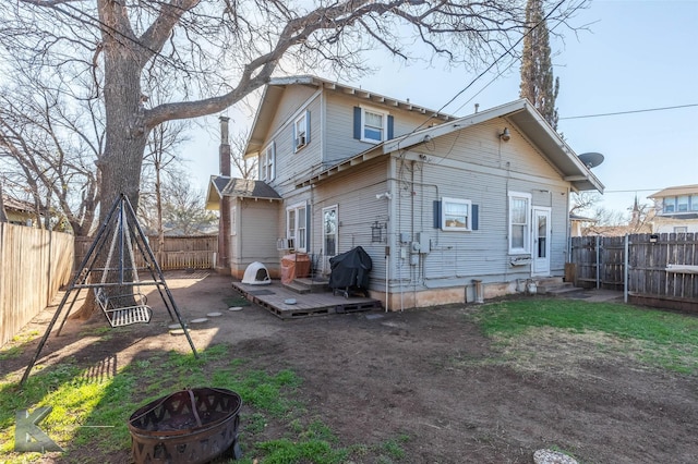 back of house with a wooden deck, entry steps, a fire pit, and a fenced backyard