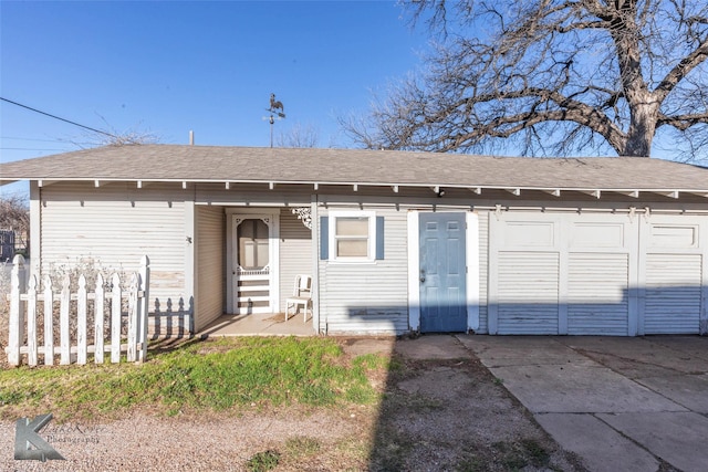 view of front of home with roof with shingles and fence