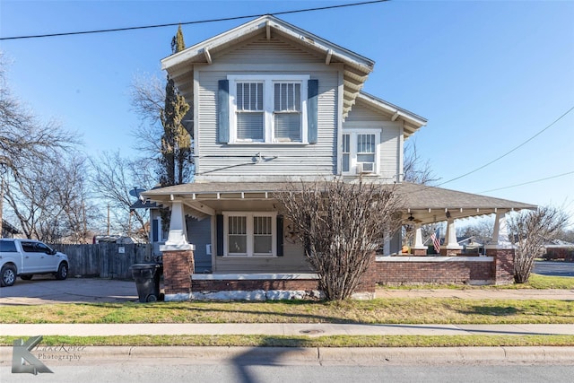 view of front of home with a porch, concrete driveway, and fence