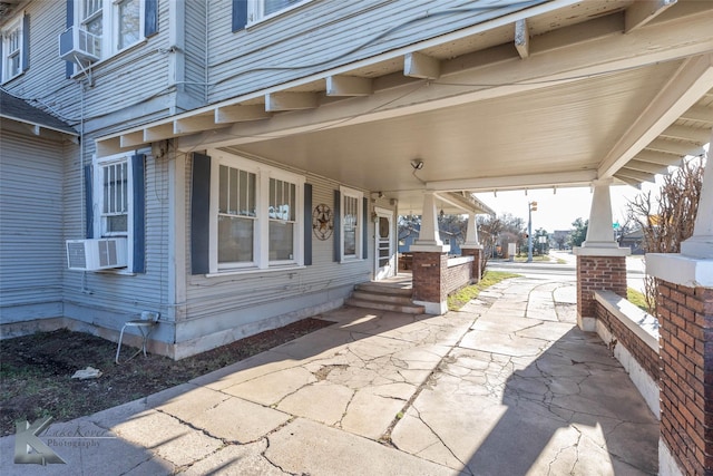 view of patio / terrace with cooling unit and a porch