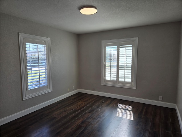 unfurnished room with baseboards, a textured ceiling, and dark wood-style flooring