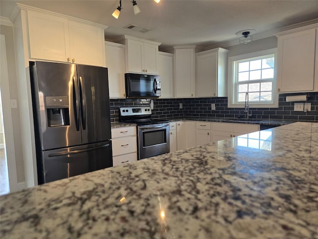 kitchen featuring visible vents, black microwave, fridge with ice dispenser, stainless steel electric range, and a sink