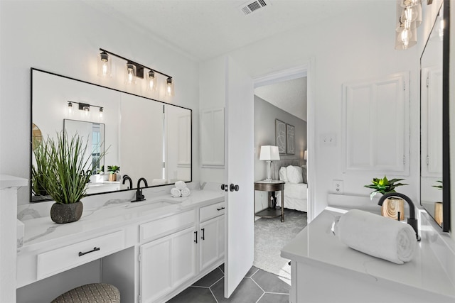 ensuite bathroom featuring tile patterned flooring, visible vents, vanity, and ensuite bath