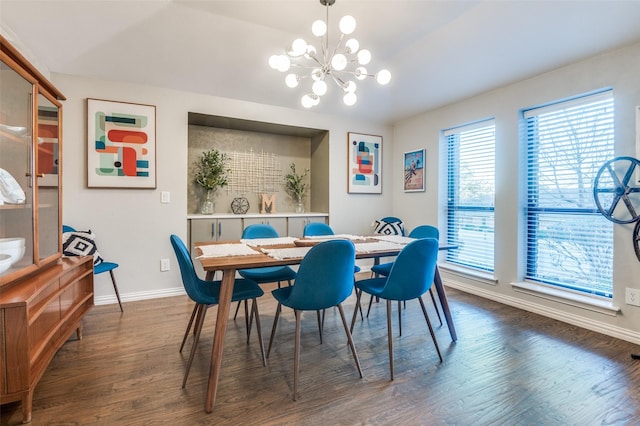 dining area featuring dark wood finished floors, an inviting chandelier, and baseboards