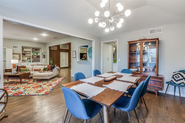 dining space with a chandelier, visible vents, and dark wood-style flooring