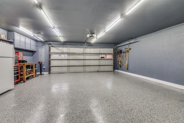 garage featuring baseboards and freestanding refrigerator