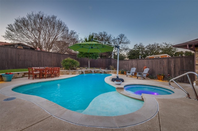 view of swimming pool with outdoor dining area, a pool with connected hot tub, a fenced backyard, and a patio area