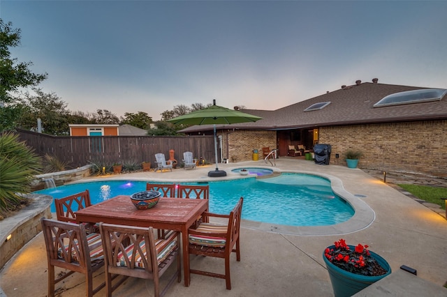 view of pool featuring a fenced in pool, a patio, a fenced backyard, outdoor dining area, and an in ground hot tub