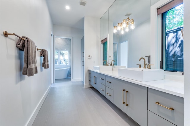 full bathroom featuring a sink, visible vents, baseboards, and double vanity