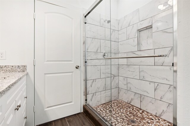 bathroom featuring vanity, wood finished floors, and a shower stall