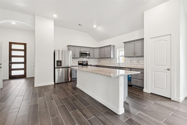 kitchen featuring visible vents, gray cabinetry, wood finish floors, appliances with stainless steel finishes, and arched walkways