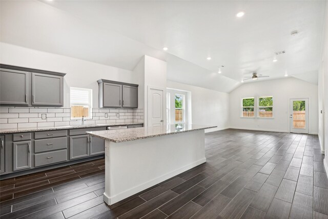 kitchen with ceiling fan, gray cabinets, backsplash, and wood finish floors