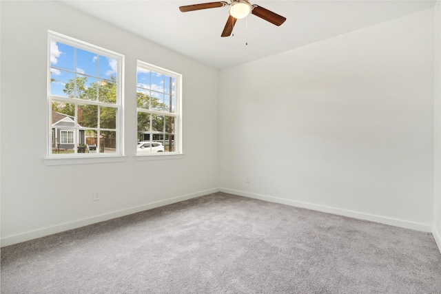 empty room with ceiling fan, baseboards, and carpet floors