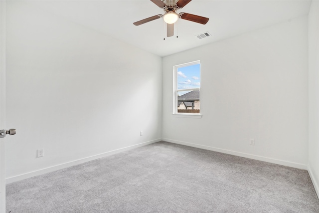 spare room with a ceiling fan, baseboards, visible vents, and carpet floors