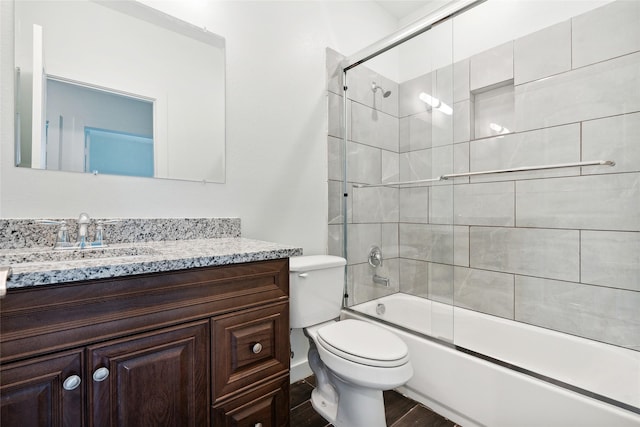 bathroom with vanity, toilet, wood finished floors, and combined bath / shower with glass door