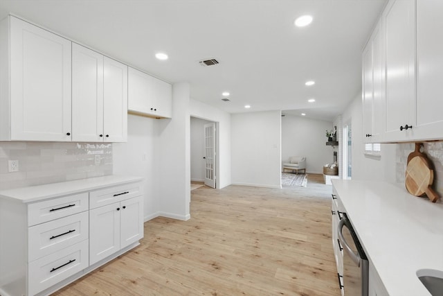 kitchen featuring light wood-type flooring, recessed lighting, light countertops, tasteful backsplash, and open floor plan