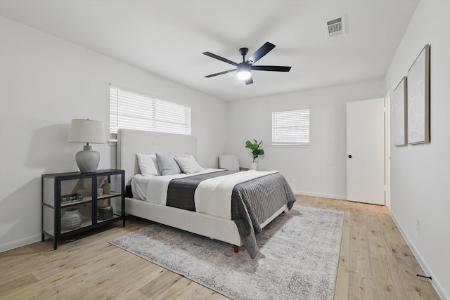 bedroom featuring a ceiling fan, baseboards, visible vents, and light wood finished floors