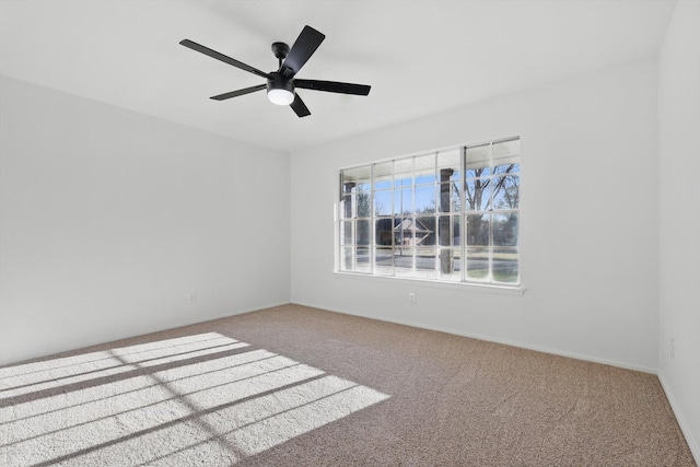 carpeted spare room with baseboards and ceiling fan