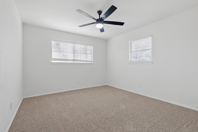 spare room with a wealth of natural light, carpet flooring, and ceiling fan