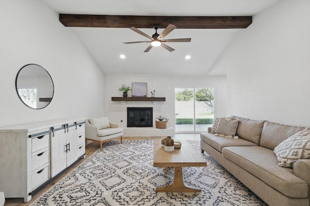 living area featuring beam ceiling, a brick fireplace, wood finished floors, and high vaulted ceiling