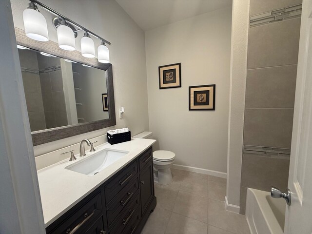 bathroom with vanity, a bath, baseboards, tile patterned flooring, and toilet