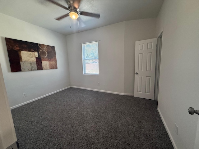 unfurnished room with ceiling fan, baseboards, and dark colored carpet