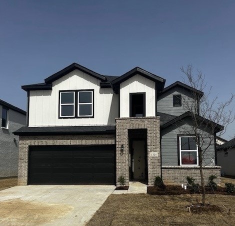 view of front of house with brick siding, an attached garage, and concrete driveway