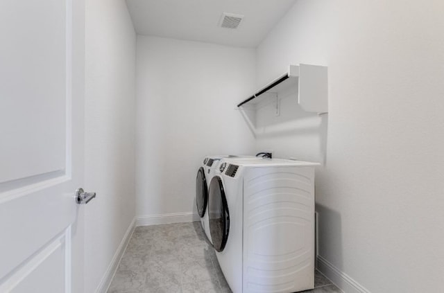 laundry area with washer and clothes dryer, laundry area, baseboards, and visible vents