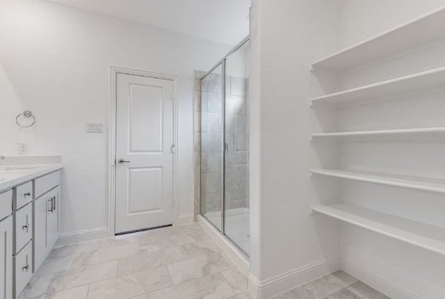 bathroom with a shower stall, vanity, marble finish floor, and baseboards