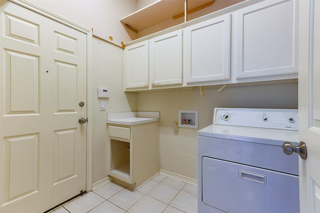 clothes washing area with washer / dryer, light tile patterned flooring, cabinet space, and baseboards