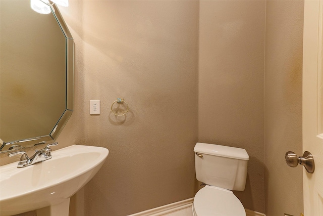 half bathroom featuring toilet and a sink