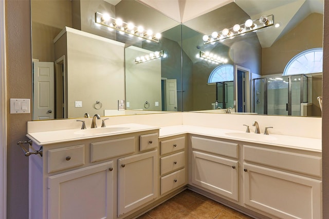 full bath featuring a sink, double vanity, a shower stall, and tile patterned flooring