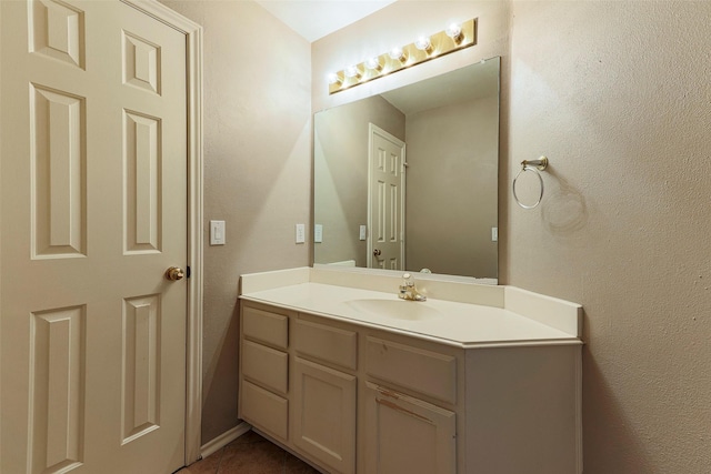 bathroom featuring vanity and a textured wall