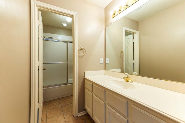 full bath featuring tile patterned flooring, vanity, and enclosed tub / shower combo