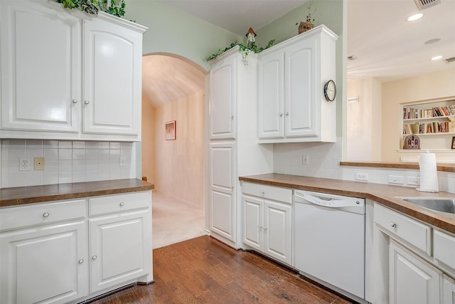 kitchen with recessed lighting, arched walkways, white dishwasher, dark wood-style flooring, and white cabinets