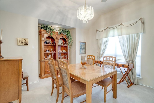 dining room with baseboards, lofted ceiling, light colored carpet, and a chandelier