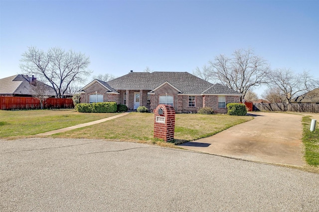 view of front of property with brick siding, a front lawn, and fence