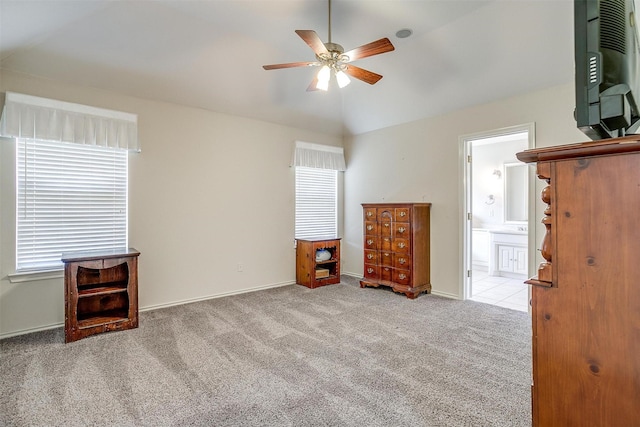 unfurnished bedroom featuring ceiling fan, lofted ceiling, carpet flooring, and connected bathroom