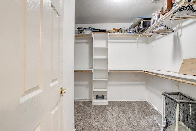 spacious closet featuring carpet and built in desk