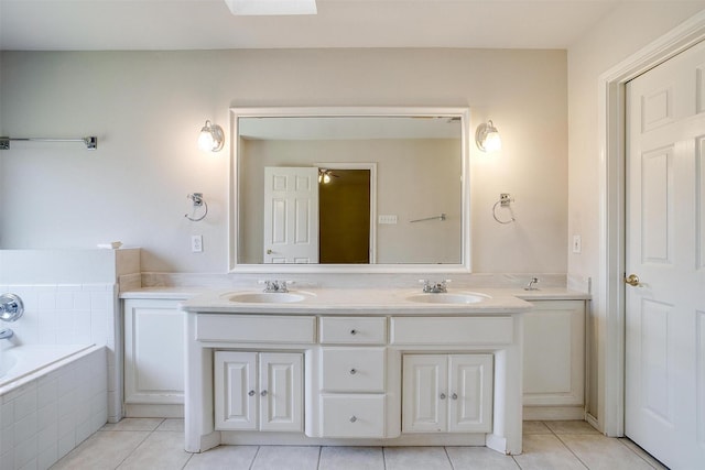 bathroom featuring tile patterned flooring, double vanity, a garden tub, and a sink