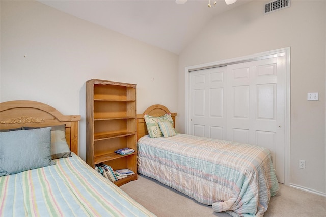 bedroom featuring a closet, visible vents, lofted ceiling, and carpet floors