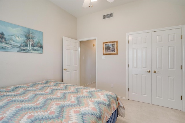 bedroom featuring visible vents, a closet, baseboards, light colored carpet, and ceiling fan