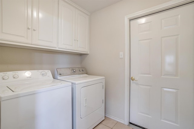 laundry room with baseboards, cabinet space, washing machine and dryer, and light tile patterned flooring