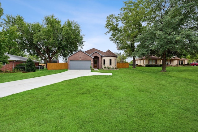 view of front of home with a garage, concrete driveway, a front yard, and fence