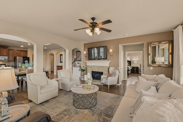 living area featuring ceiling fan, recessed lighting, a fireplace, wood finished floors, and arched walkways