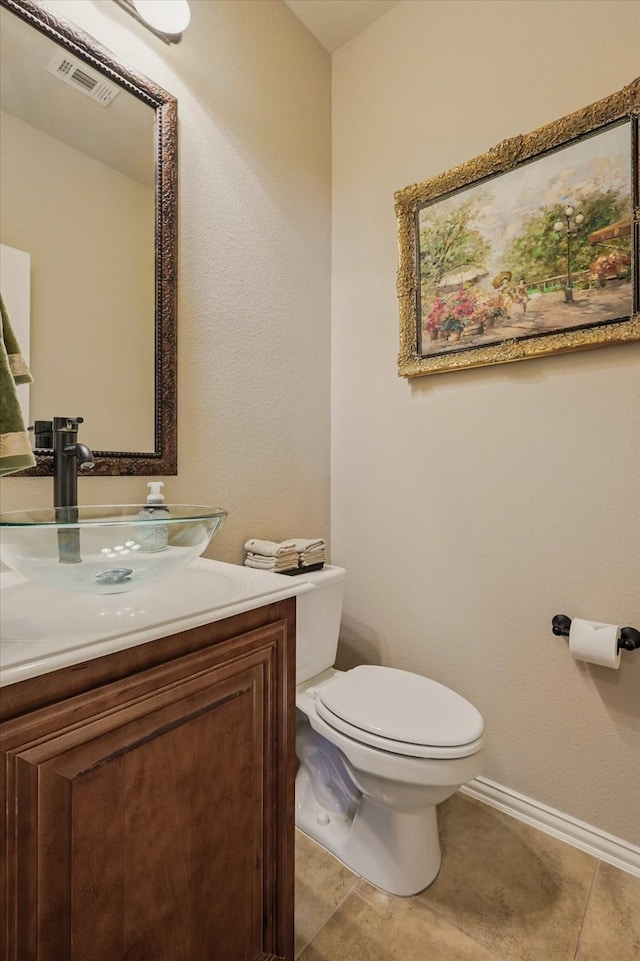 half bathroom with tile patterned flooring, visible vents, baseboards, toilet, and vanity