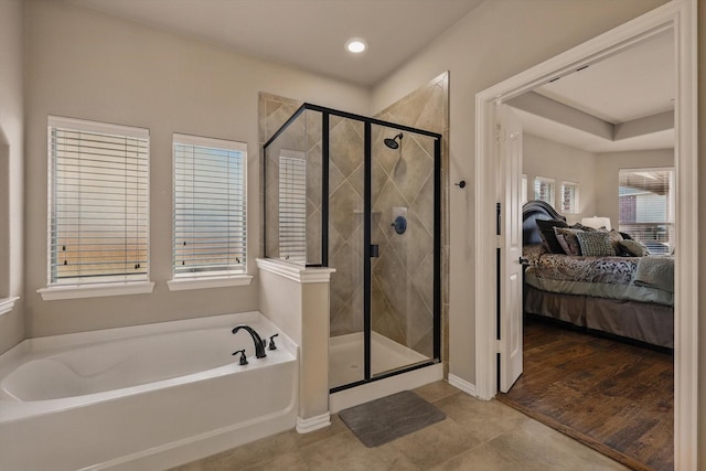 ensuite bathroom featuring tile patterned floors, connected bathroom, a bath, and a shower stall