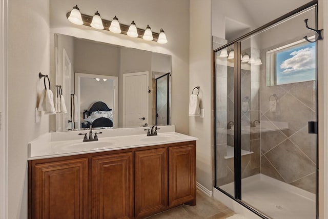 full bathroom featuring a shower stall, double vanity, ensuite bathroom, and a sink