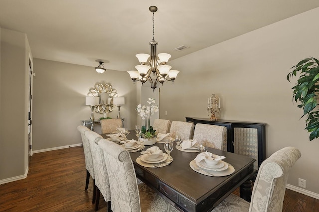 dining space with visible vents, wood finished floors, baseboards, and a chandelier