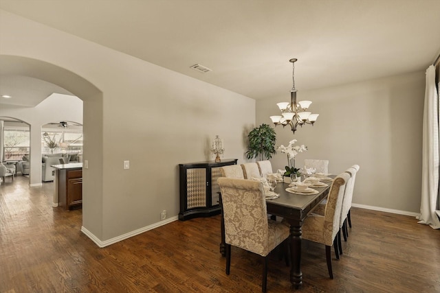 dining area with visible vents, arched walkways, baseboards, and dark wood-style flooring